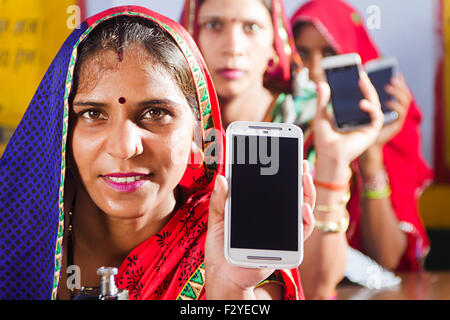 3 femmes rurales indiennes Téléphone Mobile sur mesure montrant la qualité Banque D'Images