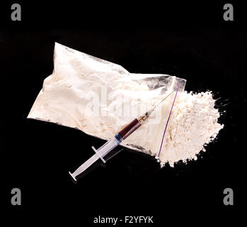 Poudre de drogues, le trafic de drogue et cuite seringue cuillère sur gros plan sur un fond noir. Banque D'Images