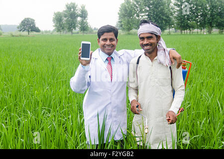 2 médecin indien et les agriculteurs ruraux Qualité Téléphone Mobile ferme montrant Banque D'Images