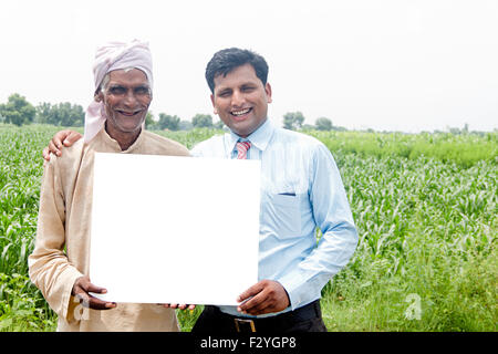 2 l'homme d'affaires rurales indiennes et farmer farm Message Board montrant Banque D'Images