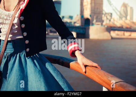 Young woman is holding et appuyé contre la rampe sur le pont d'un navire sur une croisière sur le fleuve Banque D'Images