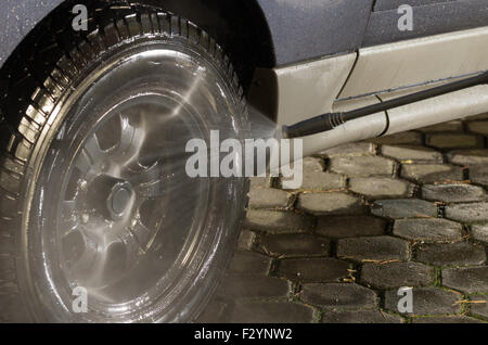 Pneu de voiture noire se laver détaillées de l'eau haute pression nettoyant. Banque D'Images