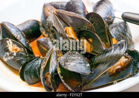 Un plat de moules des photos avec la sauce tomate, ouvert, prêt à manger, d'une table se propager. Banque D'Images