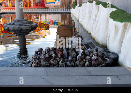 Dismaland la stupéfaction, Parc, bassin nautique '' par Banksy, avec bateaux chargés de sculptures de migrants fuyant la guerre Banque D'Images