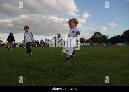 Richmond, London, UK. 26 Sep, 2015. Un enfant en pratique ses compétences avec le ballon ovale à une Coupe du Monde de Rugby en plein air le dépistage à l'Old Deer Park, Richmond, Londres SW. Des centaines de fans se sont réunis pour regarder une série de matchs sur grand écran non loin du Stade de Twickenham. Crédit : à vue/Photographique Alamy Live News Banque D'Images