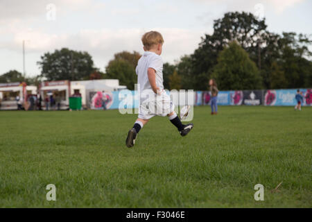 Richmond, London, UK. 26 Sep, 2015. Un enfant en pratique ses compétences avec le ballon ovale à une Coupe du Monde de Rugby en plein air le dépistage à l'Old Deer Park, Richmond, Londres SW. Des centaines de fans se sont réunis pour regarder une série de matchs sur grand écran non loin du Stade de Twickenham. Crédit : à vue/Photographique Alamy Live News Banque D'Images