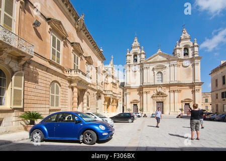 Bâtiments baroques autour de square à l'intérieur des remparts et bleu voiture garée sur une journée ensoleillée à Mdina, Malte. Banque D'Images