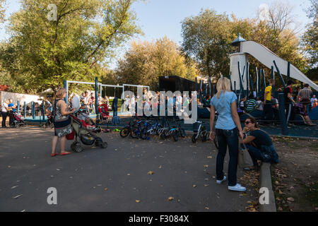 Moscou, Russie. Samedi, 26 Septembre, 2015. Accueil chaleureux, doux, calme et généralement très confortable week-end à Moscou, Russie. La température ambiante  +26 °C (78,8 °F) me rappelle de l'été dernier. Un grand nombre de personnes et les familles passent la journée en plein air. Les Moscovites ont inondé le Parc Gorki de Moscou ainsi que d'autres parcs de la ville. Un parking au milieu de parc Gorky. Les personnes sont occupées dans l'aire de jeux. Pour être honnête, sous la supervision de leurs mamans et papas, Crédit : Alex's Pictures/Alamy Live News Banque D'Images