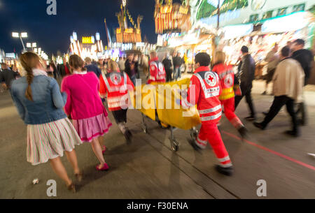 Munich, Allemagne. Sep 23, 2015. Les ambulanciers de la Croix-Rouge allemande pousser un brancard à un emplacement du 182ème Oktoberfest à Munich, Allemagne, 23 septembre 2015. 8 000 patients ont été traités à la station de premiers secours géré par la Croix-Rouge allemande l'année dernière, avec 680 d'entre eux souffrant d'empoisonnement à l'alcool. Le plus grand festival de la bière qui se déroulera jusqu'au 04 octobre 2015 devrait attirer quelque 6 millions de visiteurs de partout dans le monde cette année. Photo : MATTHIAS BALK/dpa/Alamy Live News Banque D'Images