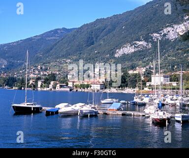 Les petits bateaux amarrés le long des jetées en bois avec bâtiments au bord de l'eau à l'arrière, Menaggio, Lac de Côme, Lombardie, Italie, Europe Banque D'Images