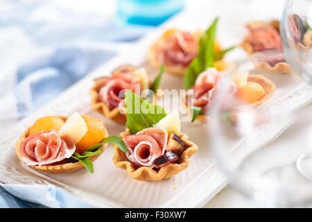 Tartelettes à la viande, basilic, boules de melon et de figue. Banque D'Images