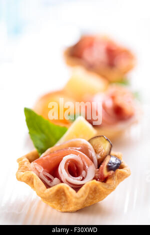 Tartelettes à la viande, basilic, boules de melon et de figue. Shallow dof. Se concentrer sur les parties de la viande. Banque D'Images