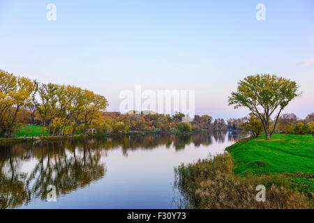 Rivière avec reflétant les arbres et Ciel en automne Park au coucher du soleil Banque D'Images