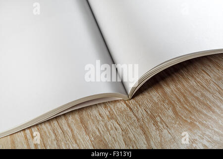 Photo. Fragment de livre ouvert vide sur fond en bois clair avec des ombres douces close-up. Pour la conception de présentations et portfol Banque D'Images