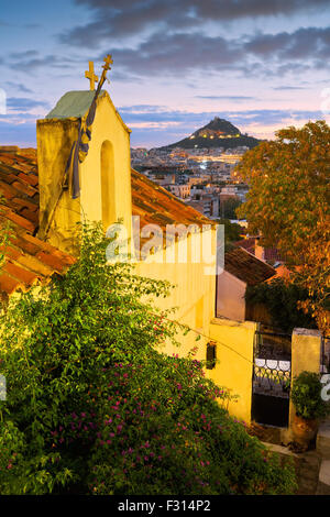 Vue sur le mont Lycabette et une petite église orthodoxe grecque à l'Anafiotika, Athènes. Banque D'Images