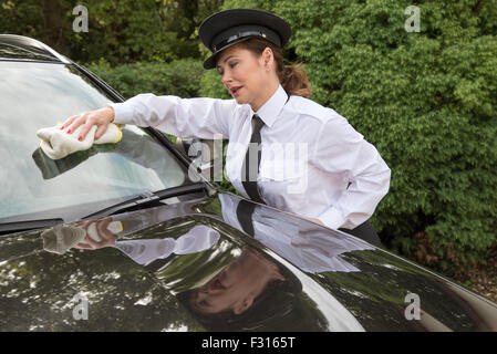 Femme en uniforme de pilote professionnel du polissage des vitres de voiture prêt pour travailler Banque D'Images