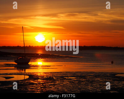 Coucher de soleil sur le port de Portsmouth, Hampshire, Angleterre. Vu de la côte de l'île de baleine Creek. Banque D'Images