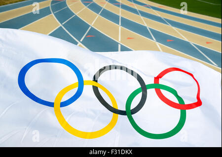 La VILLE DE NEW YORK, USA - 20 août 2015 : drapeau olympique au cours des vagues d'un voies bleu et tan d'une piste de course. Banque D'Images