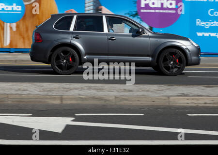 Un flou déménagement Porsche Cayenne en vitesse le motion blur sur 'The Strand' à Liverpool, Liverpool, Merseyside, Royaume-Uni Banque D'Images