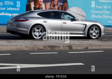 Un flou déménagement Porsche Panamera en vitesse le motion blur sur 'The Strand' à Liverpool, Liverpool, Merseyside, Royaume-Uni Banque D'Images