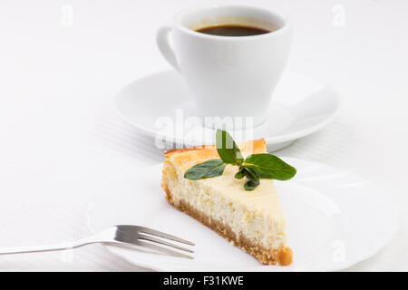 Coin de cheesecake avec des feuilles de menthe avec fourchette à dessert Banque D'Images