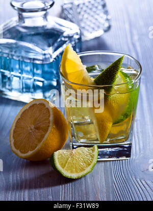 Gin avec du citron et de la glace sur la vieille table en bois Banque D'Images