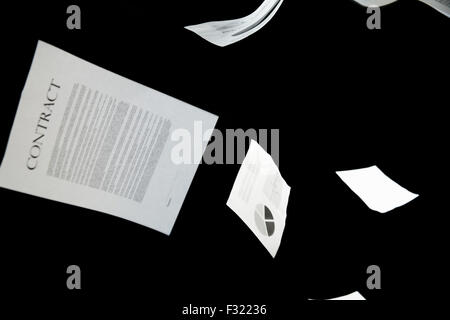 Les papiers d'affaires tomber sur fond noir Banque D'Images