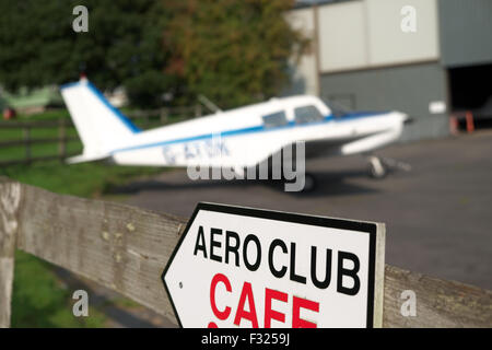 Aero Club club de vol, d'un Piper PA-28 Cherokee garé sur l'aire à l'extérieur d'un hangar à un petit aérodrome en UK Banque D'Images