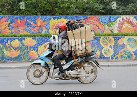 Les cyclomoteurs et les motos sont partout à Hanoi, Vietnam. Ce n'est pas rare de voir d'énormes charges sur un scooter. Banque D'Images
