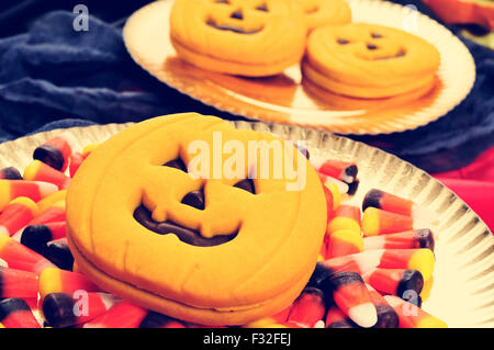 Certains bacs avec des cookies en forme de citrouille et quelques bonbons Halloween différents, avec un effet de filtre Banque D'Images