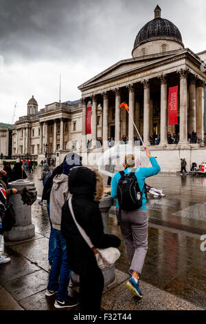 Les visiteurs se tient en dehors de la National Gallery de la pluie, Londres, UK Banque D'Images