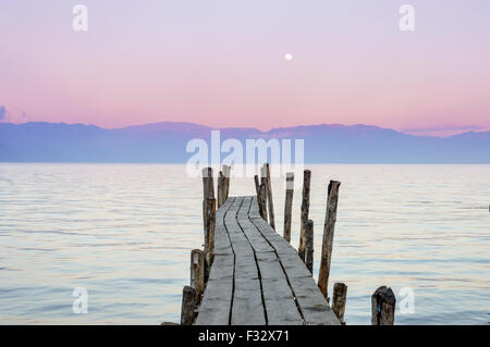 Petit bateau en bois avec le dock de ciel coucher de soleil rose sur l'arrière-plan dans le lac Atitlan, Guatemala Banque D'Images