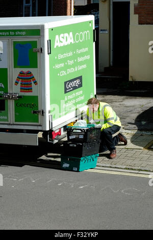 L'asda mâle employé fait une livraison à domicile de courses dans une rue urbaine england uk Banque D'Images