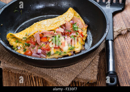 Poêle à omelette au jambon et au fromage sur fond de bois rustique Banque D'Images