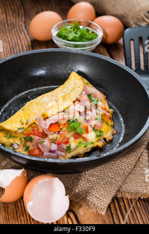 Poêle à omelette au jambon et au fromage sur fond de bois rustique Banque D'Images