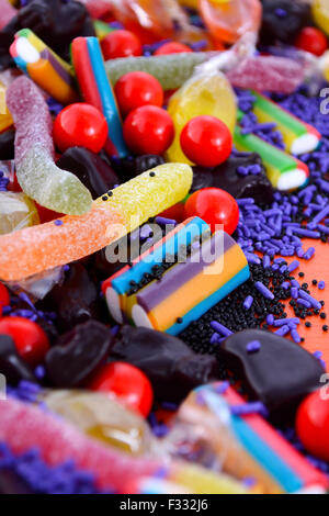 Bonbons colorés lumineux libre sur fond de bois orange pour Halloween Trick or Treat, ou fête d'enfants. Banque D'Images