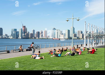 La VILLE DE NEW YORK, USA - Le 29 août 2015 : l'entraîneur personnel de fitness boot camp groupe conduit près de classe l'Hudson. Banque D'Images