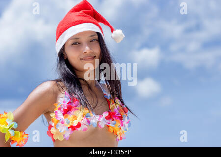 Hawaii hula dancer avec chapeau de Père Noël sur fond bleu Banque D'Images