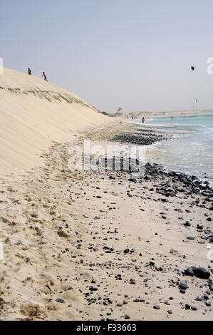 Silhouettes de personnes marchant le long d'une côte de sable sur une plage idyllique à Boa Vista sur l'île république du Cap-Vert Banque D'Images