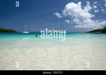 Plage d'Anse Lazio, voiliers, mer turquoise, de l'Océan Indien, l'île de Praslin, Seychelles Banque D'Images