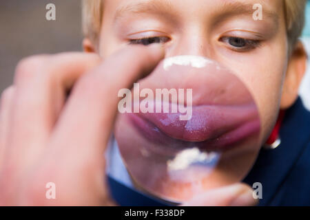 Boy holding a magnifying glass Banque D'Images