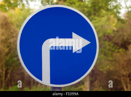 Panneau routier sous la forme d'un cercle bleu avec une flèche blanche indiquant l'admis torsion sur l'autoroute. Banque D'Images
