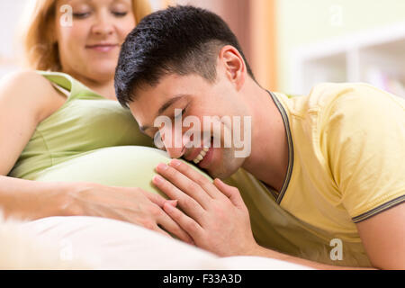 L'homme joyeux de ventre embrasse sa femme enceinte Banque D'Images