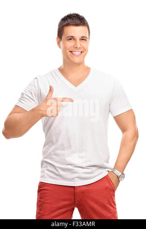 Shot vertical d'un jeune homme dans un simple chemise blanche pointant avec son doigt à sa gauche isolé sur fond blanc Banque D'Images