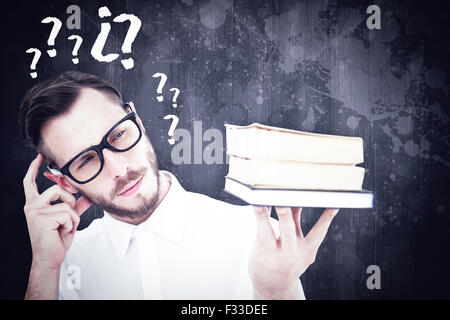 Image composite de geeky jeune homme à la pile de livres à Banque D'Images