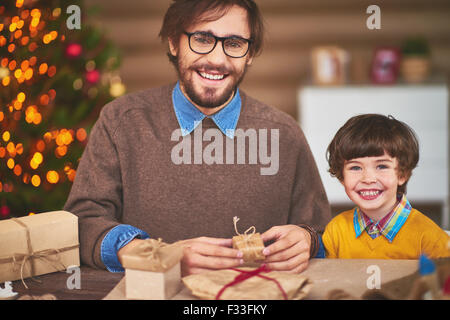 Heureux jeune homme et de son fils la préparation de surprises de Noël pour les amis Banque D'Images