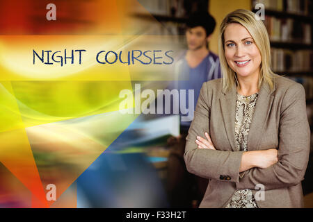 Cours du soir contre le professeur looking at camera with arms folded Banque D'Images