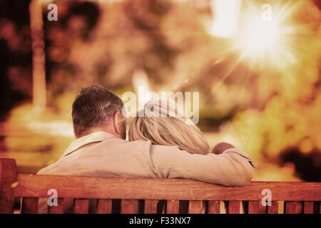 Image composite du couple de personnes âgées assis sur le banc avec leur retour à l'appareil photo Banque D'Images