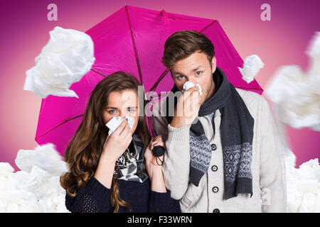 Image composite du couple blowing nose alors que holding umbrella Banque D'Images