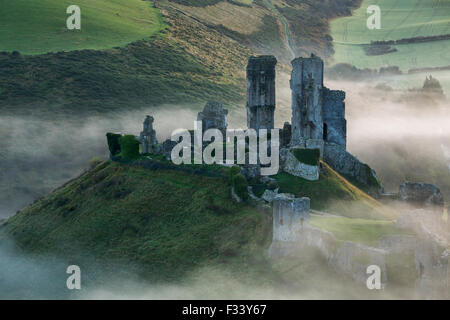 Château de Corfe dans la brume à l'aube, Dorset, England, UK Banque D'Images